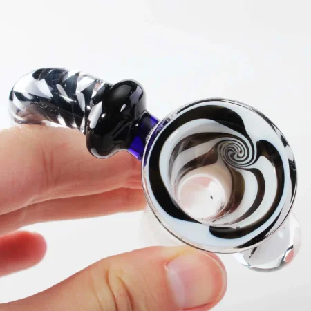 Detail misky skleněného kotlíku Black Leaf v ruce — černobílý vír uvnitř a pruhovaná rukojeť s modrým akcentem u spoje